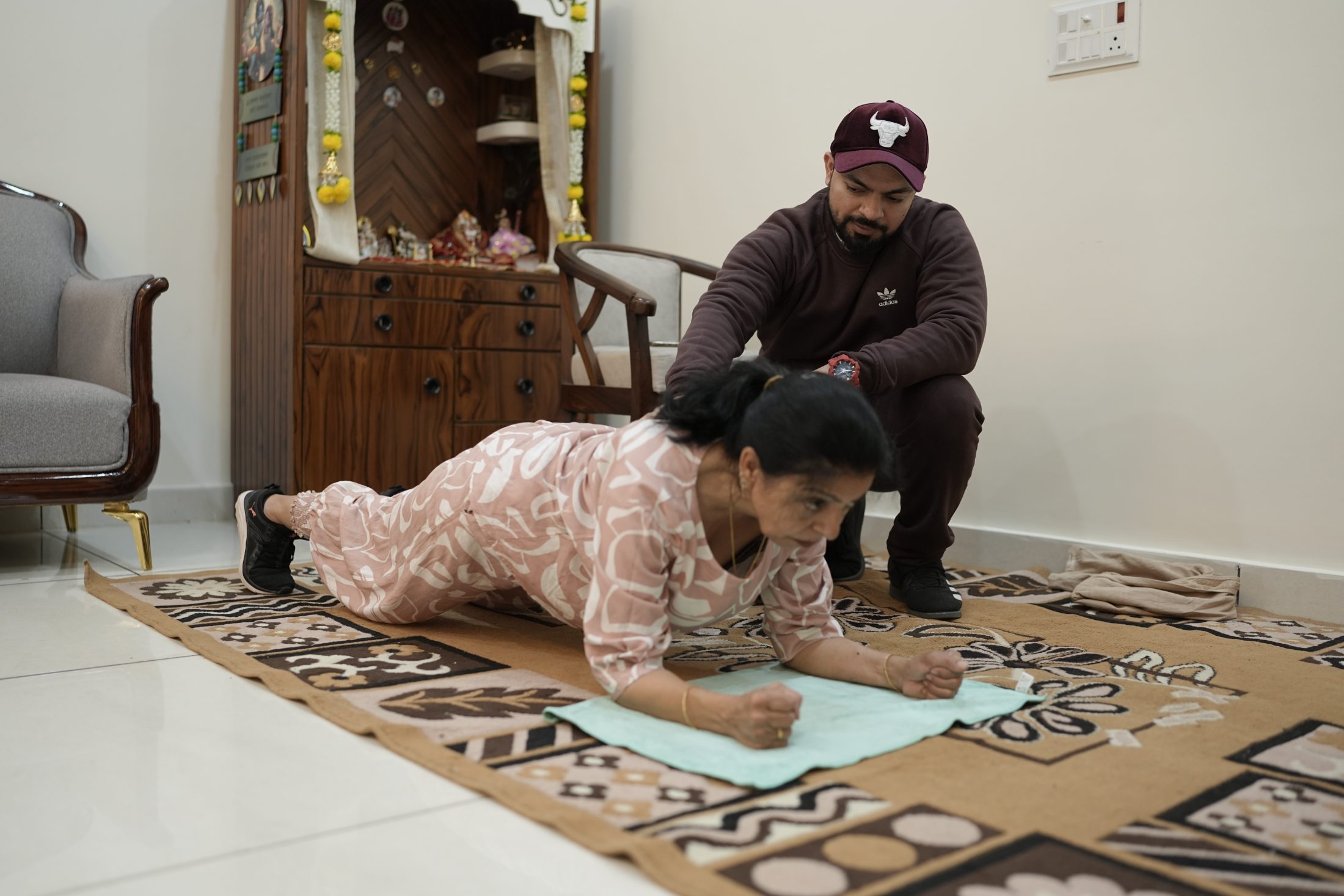 A son coaching his mother through a workout at home