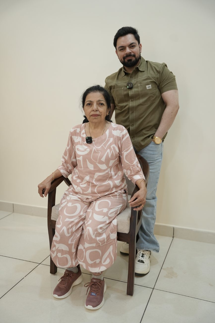 Aggam standing beside his seated mother